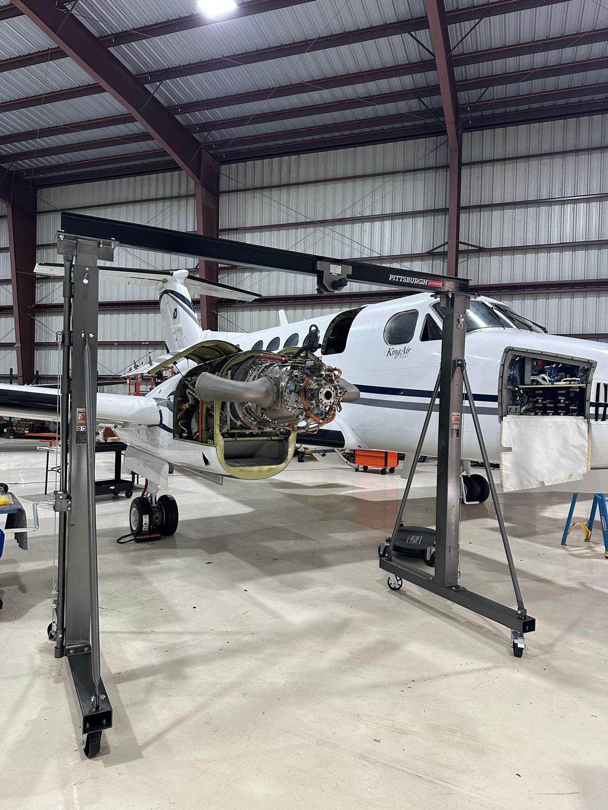 Engine gantry positioned at a King Air 350 with the powerplant exposed for removal.