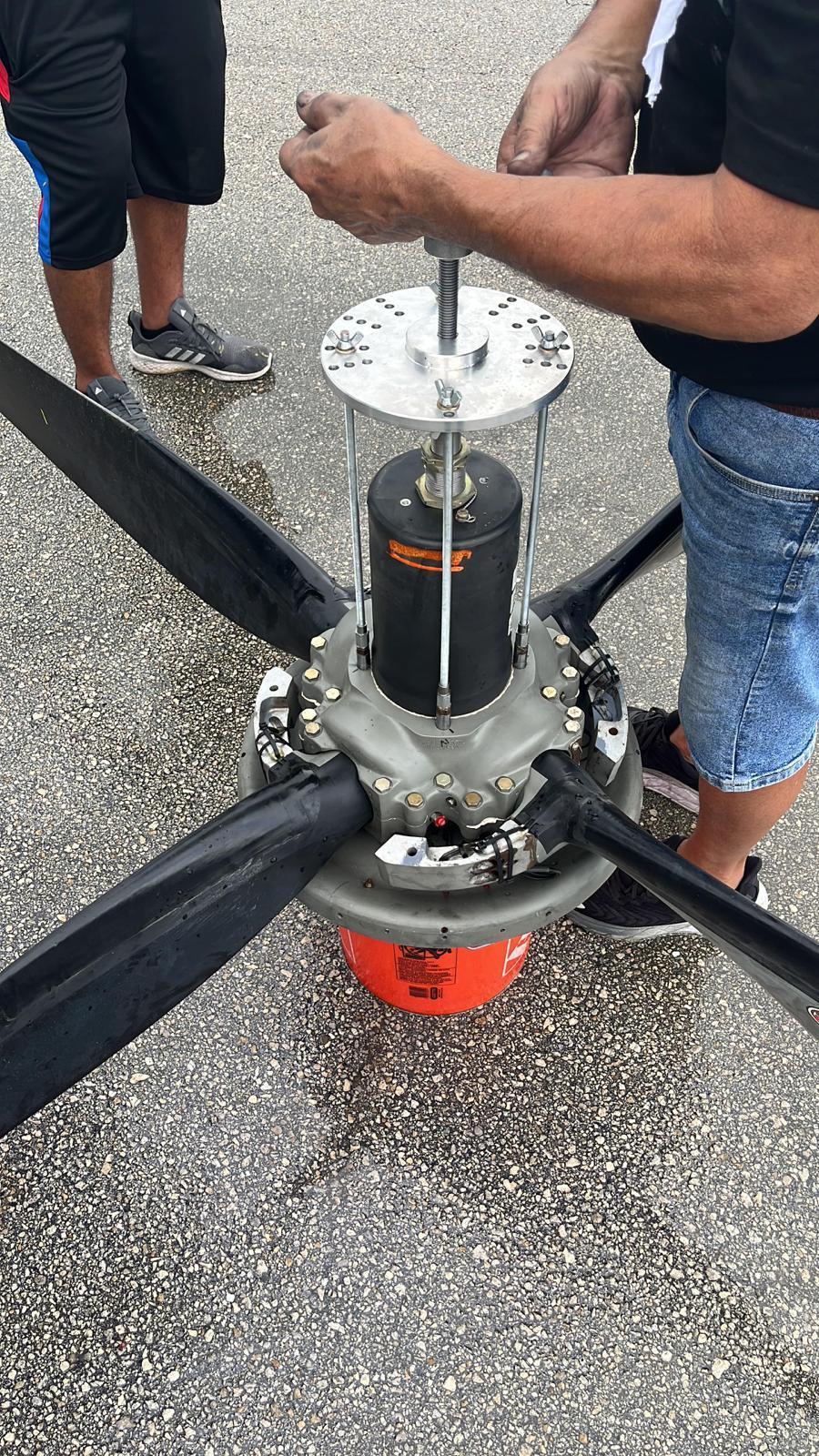 Propeller hub removed from the aircraft and supported on the ramp with a puller fitted.