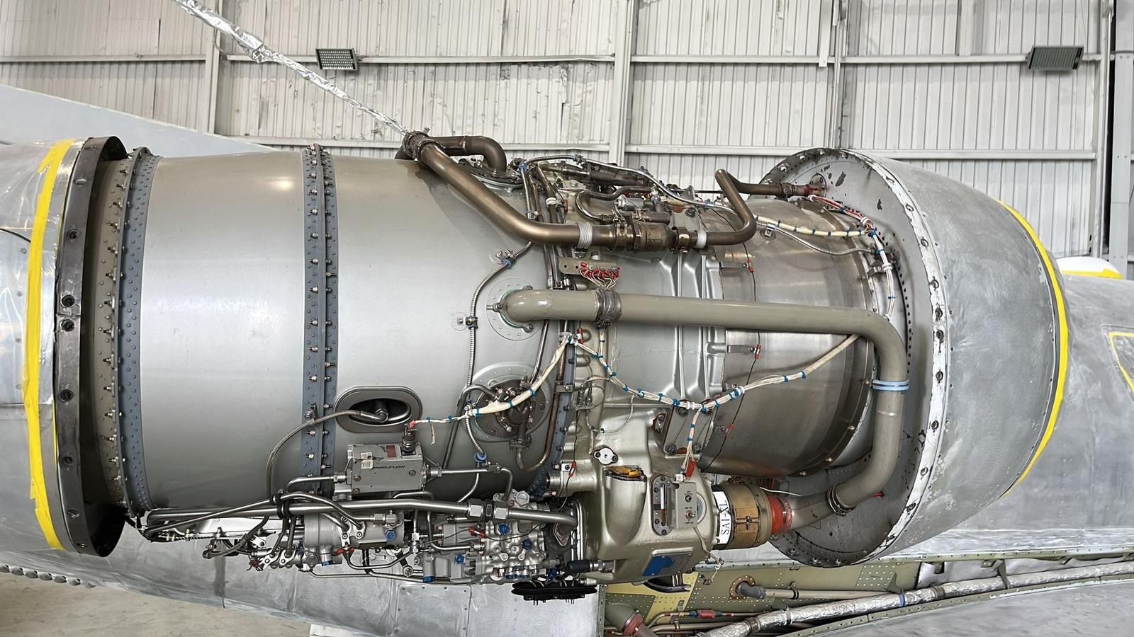 Turbofan engine core exposed showing accessory plumbing, pumps and control lines.