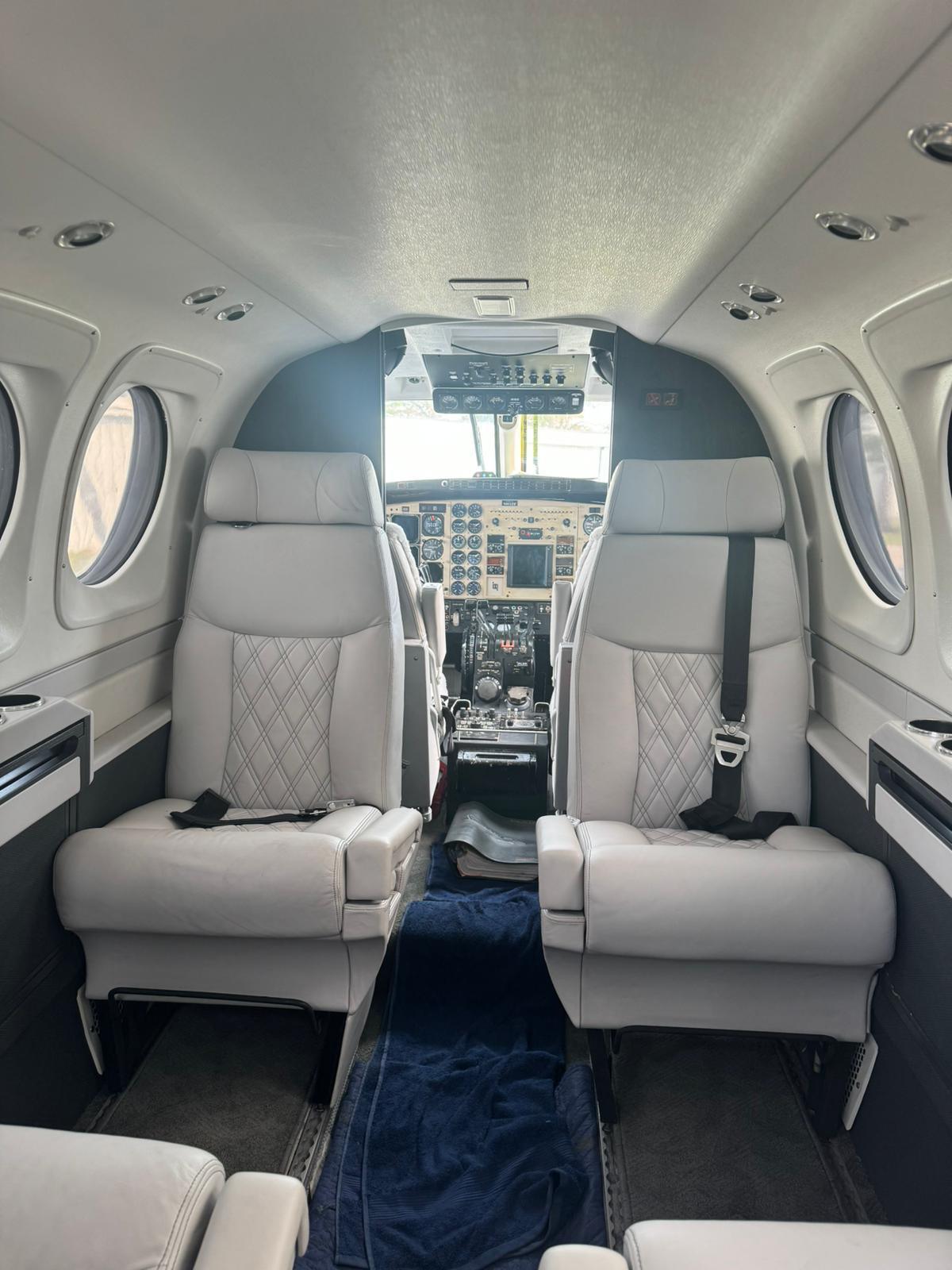 King Air cabin with pale grey diamond-stitched leather seats and navy carpet.