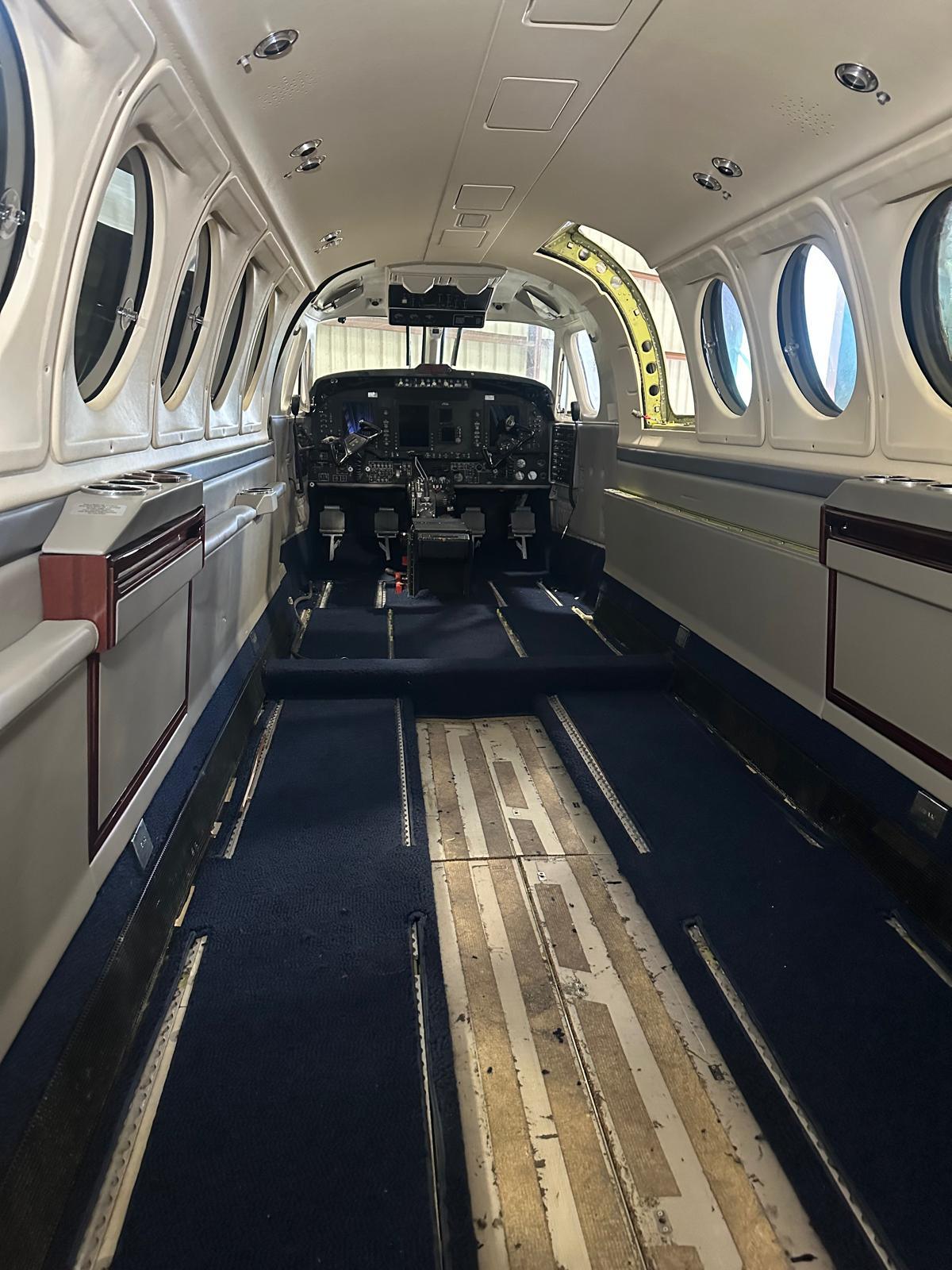 King Air cabin with seats removed and floor tracks exposed during an interior refit.