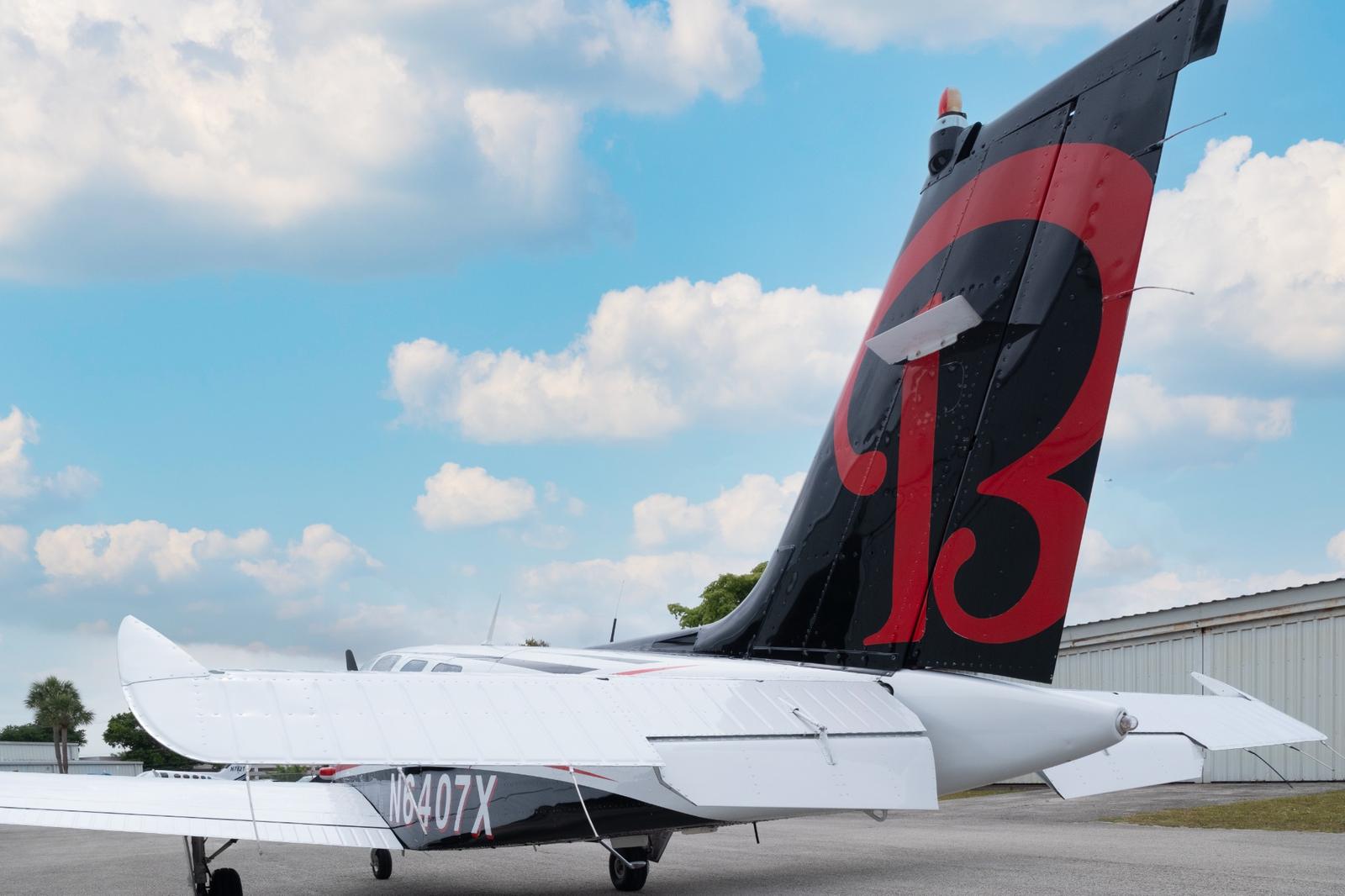Tail of Bonanza N6407X painted black with a large red number thirteen graphic.