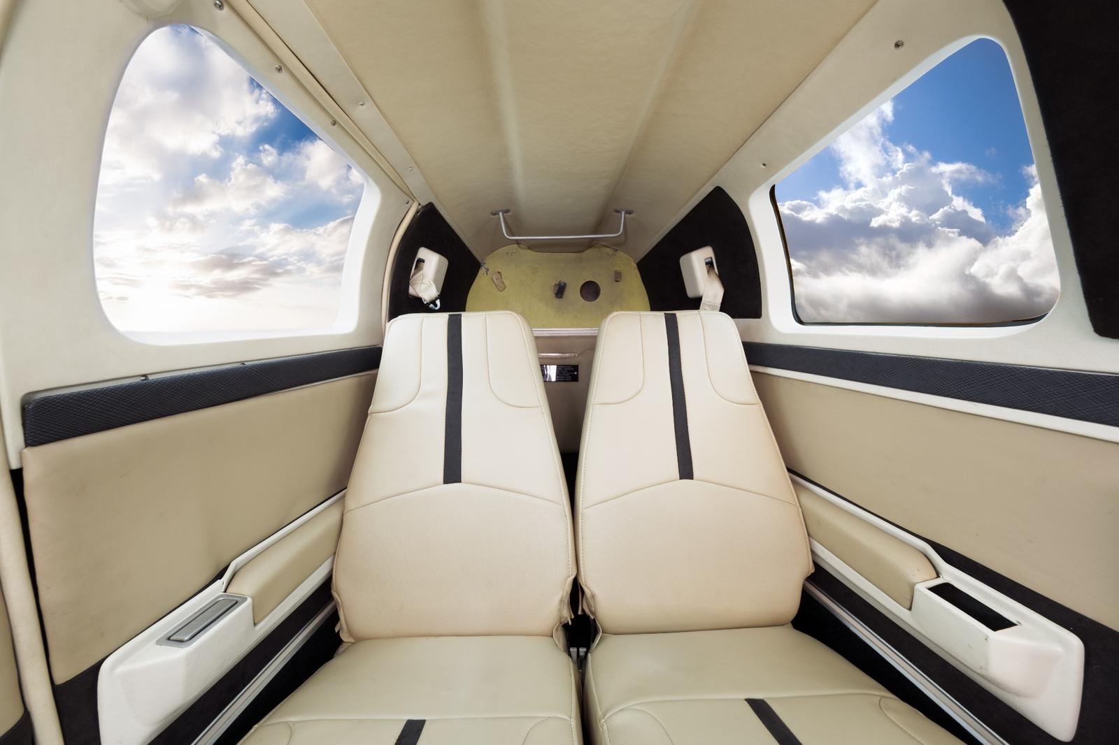 Rear cabin of the Bonanza with cream leather seats and dark accent stripes.